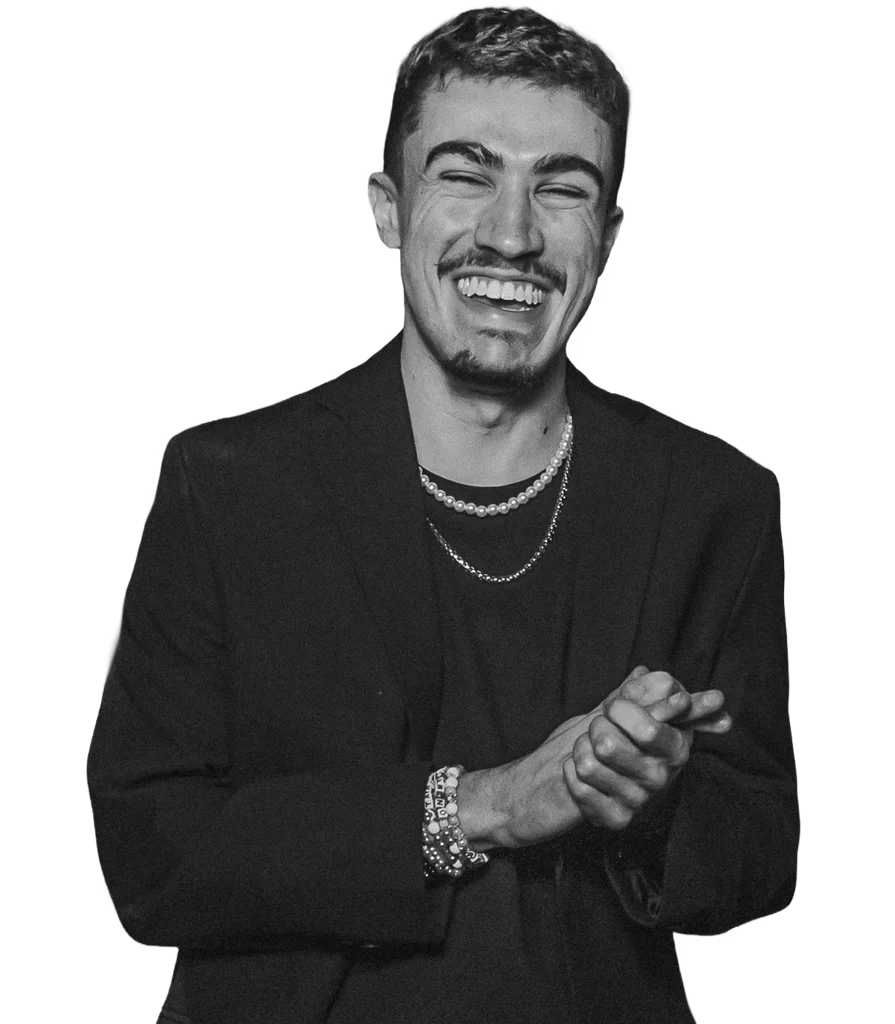Retrato em preto e branco de Miguel Liberato sorrindo, de terno